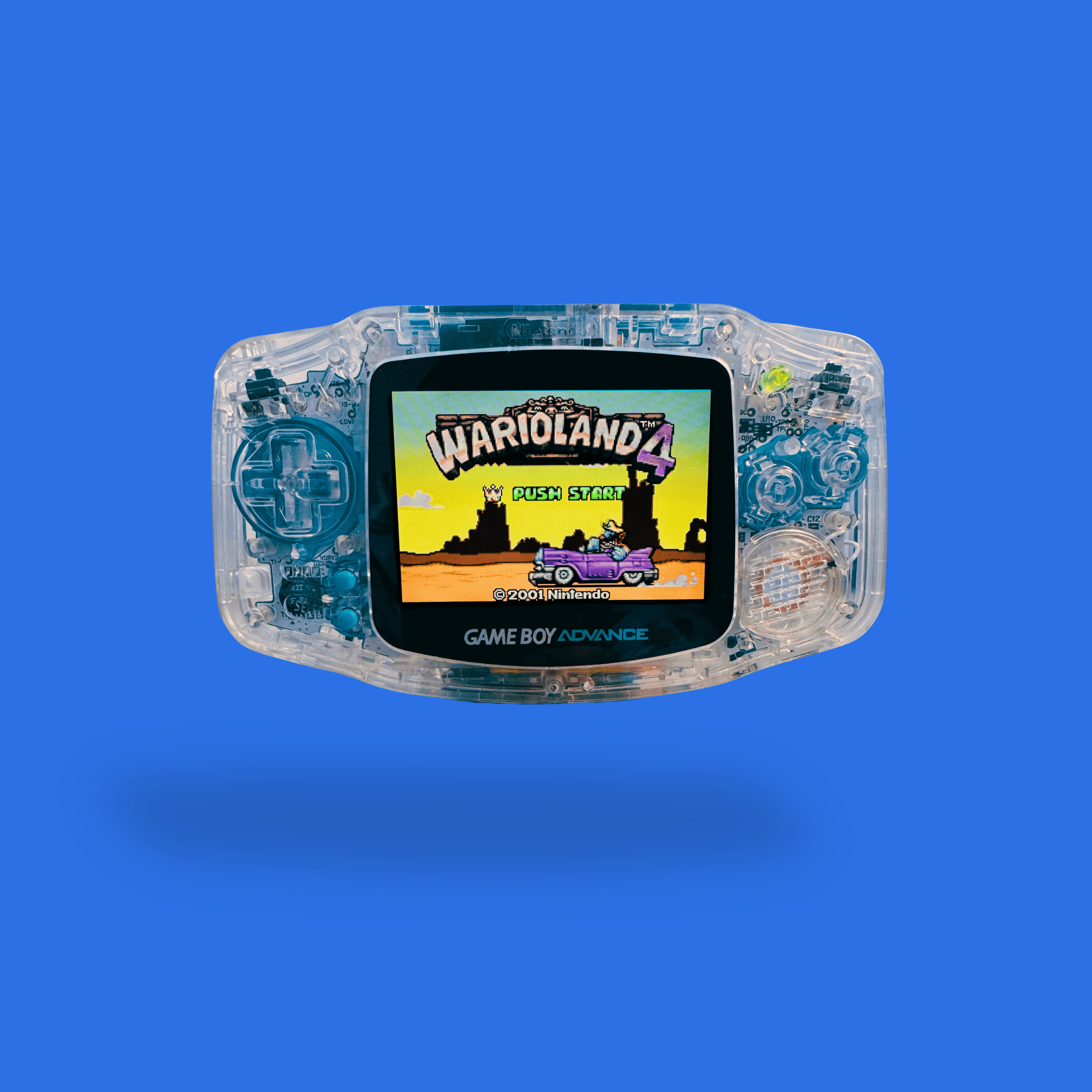 Ein von RetroGear gemoddeter transparenter Nintendo Game Boy Advance mit blauen Details und dem Spiel Wario Land 4, sichtbar auf dem Bildschirm.